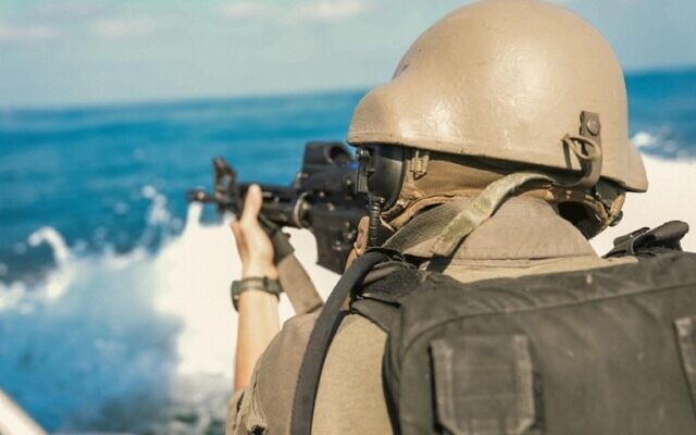 A sailor in the Navy's 914th Patrol Squadron is seen aiming a gun aboard a vessel amid a drill near Haifa, in a handout image published August 15, 2024. (Israel Defense Forces)