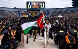 Salma Hamamy carries a Palestinian flag during an anti-Israel protest during the University of Michigan's commencement ceremony on May 4, 2024 at Michigan Stadium in Ann Arbor, Michigan. (Nic Antaya/Getty Images via JTA)