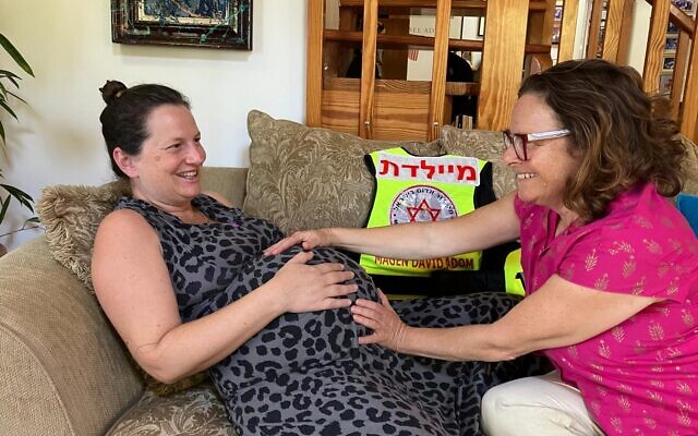 Roni Cohen, right, a midwife, checks Shira Weiss as part of the 'First Contractions' project, in Shavei Zion, Israel, August 11, 2024. (Diana Bletter/The Times of Israel)