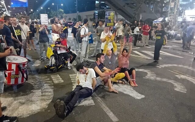 Anti-government, pro-hostage deal activists sit with hands bound on Tel Aviv's Begin Street, outside the IDF headquarters, simulating the conditions of hostages in Gaza, September 10, 2024. (Noam Lehmann/Times of Israel) Anti-government, pro-hostage deal activists sit with hands bound on Tel Aviv's Begin Street, outside the IDF headquarters, simulating the conditions of hostages in Gaza, September 10, 2024. (Noam Lehmann/Times of Israel)