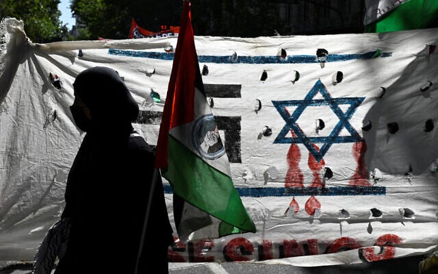 A demonstrator holds a Palestinian flag during an anti-Israel rally in front of the Israeli embassy in Buenos Aires, on October 9, 2023. (Luis Robayo/AFP) A demonstrator holds a Palestinian flag during an anti-Israel rally in front of the Israeli embassy in Buenos Aires, on October 9, 2023. (Luis Robayo/AFP)