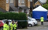 Police officers stand guard by a forensic team tent at Ashley Close in Bushey in the borough of Hertfordshire, north of London, on July 10, 2024 after a triple 'crossbow attack' murder. (Justin Tallis/AFP)