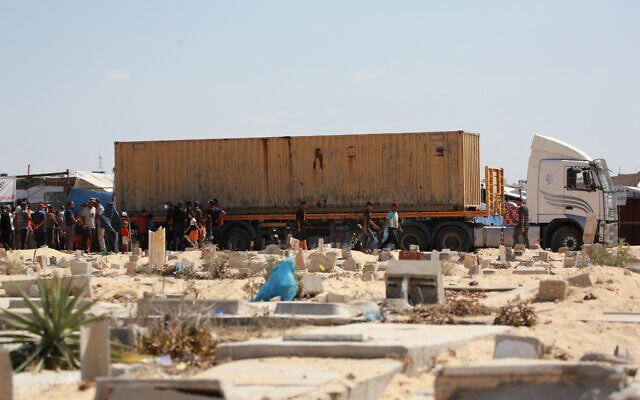 File: People surround a container transporting bodies of Palestinians that were taken and later released by Israel, ahead of a mass funeral at a cemetery in Khan Younis in the southern Gaza Strip on August 5, 2024. (Bashar TALEB / AFP) File: People surround a container transporting bodies of Palestinians that were taken and later released by Israel, ahead of a mass funeral at a cemetery in Khan Younis in the southern Gaza Strip on August 5, 2024. (Bashar TALEB / AFP)