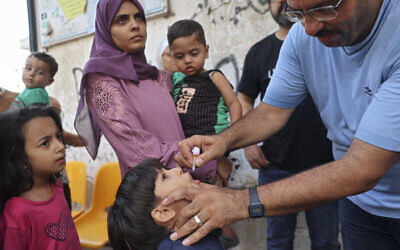 A health worker administers the polio vaccine to a Palestinian child in Zawayda in the central Gaza Strip on September 1, 2024, amid the ongoing conflict between Israel and the Hamas terror group. (Photo by Eyad BABA / AFP)