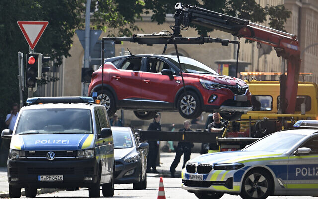 Police officers remove a car with an Austrian plate with a crane as they secure the area after a shooting near the Israeli consulate in Munich on September 5, 2024. (LUKAS BARTH-TUTTAS / AFP) Police officers remove a car with an Austrian plate with a crane as they secure the area after a shooting near the Israeli consulate in Munich on September 5, 2024. (LUKAS BARTH-TUTTAS / AFP)