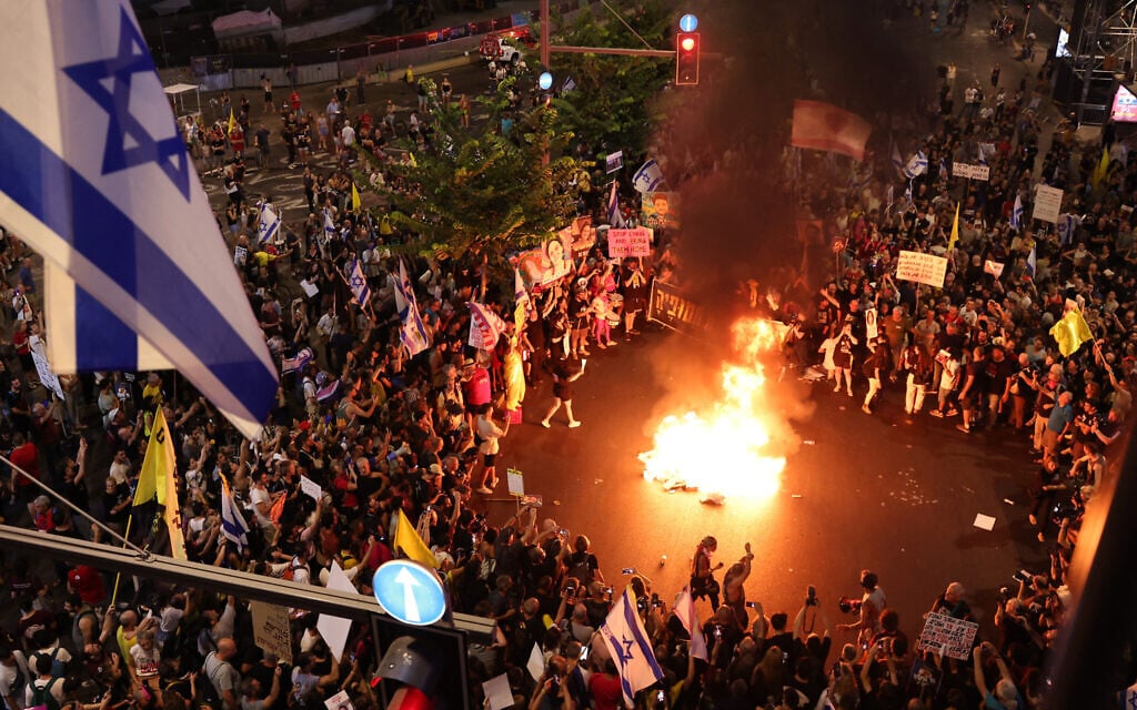 Demonstrators light a fire during a protest calling for action to secure the release of Israeli hostages held captive by Hamas in Gaza, in front of the Israeli Defence Ministry in Tel Aviv on September 7, 2024 (Jack GUEZ / AFP)