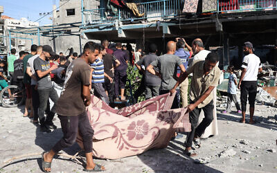 People use a blanket to transport a casualty after an Israeli airstrike hit the Al-Jawni (Jaouni) school in Nuseirat, where the IDF says Hamas was operating, in the central Gaza Strip on September 11, 2024. (Eyad BABA / AFP)