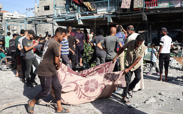 People use a blanket to transport a casualty after an Israeli airstrike hit the Al-Jawni (Jaouni) school in Nuseirat, where the IDF says Hamas was operating, in the central Gaza Strip on September 11, 2024. (Eyad BABA / AFP)