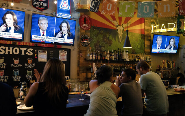 People sit behind a bar as they attend a watch party for the US Presidential debate between Vice President and Democratic presidential candidate Kamala Harris and former US President and Republican presidential candidate Donald Trump at American Eat Co. in Tucson, Arizona, on September 10, 2024. (Rebecca Noble/AFP)