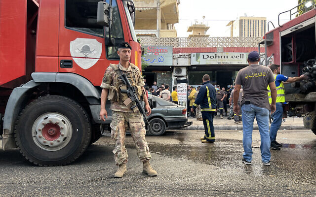 A Lebanese army soldier stands guard near fire trucks at the scene of an explosion in Saida in southern Lebanon on September 18, 2024.  (Mahmoud ZAYYAT / AFP)