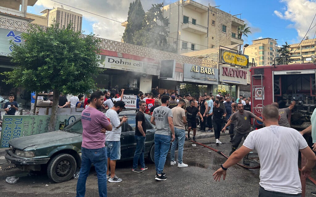 People gather as firefighters put out the flames at the scene of a device explosion in Saida in southern Lebanon on September 18, 2024, a day after thousands of Hezbollah pagers exploded in an attack blamed on Israel. (Mahmoud ZAYYAT / AFP)