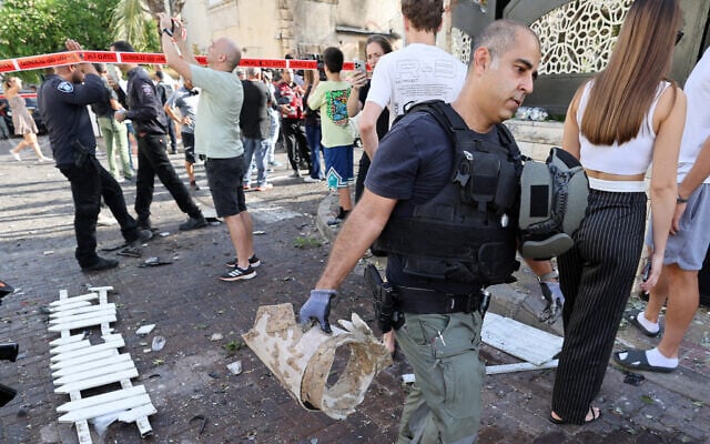 A sapper carries a piece from a rocket fired from Lebanon that hit a home in Kiryat Bialik on September 22, 2024. (Photo by Jack GUEZ / AFP)