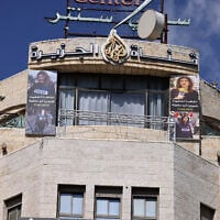 Pictures of slain al-Jazeera journalist Shireen Abu Akleh hang on the facade of the building housing the television station's office in Ramallah in the West Bank, after Israel issued a 45-day closure order on September 22, 2024.  (JAAFAR ASHTIYEH / AFP)