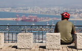 A man sits overlooking the port of Haifa on September 24, 2024. (Jack GUEZ / AFP)