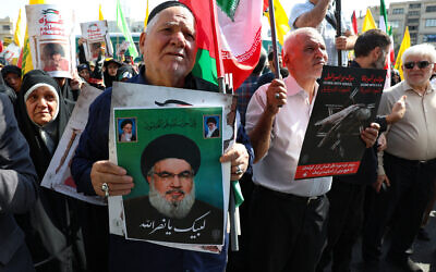 An Iranian man raises a picture of Lebanon's Hezbollah chief Hassan Nasrallah during an anti-Israel protest in Tehran on September 27, 2024. (AFP)