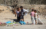 Palestinian children salvage items from garbage in Deir el-Balah in the central Gaza Strip, September 30, 2024. (Eyad Baba / AFP)