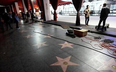 Crew members and media work near the Hollywood Walk of Fame, March 8, 2023, outside the Dolby Theatre in Los Angeles. (AP Photo/Chris Pizzello)