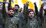 Illustrative: Hezbollah fighters raise their fists and shout slogans during the funeral of their senior commander Ali Dibs who was killed by an Israeli airstrike in Nabatiyeh town, south Lebanon, February 16, 2024. (AP Photo/Mohammed Zaatari)