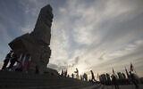People lay a wreath at the monument to the 1939 heroic defense of the Westerplatte peninsula outpost during solemn observances of the 85th anniversary of the outbreak of World War II, at Westerplatte, on the Baltic Sea, Poland,  September 1, 2024. (Wojciech Strozyk/AP)