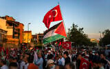 People wave Turkish and Palestinian flags during an anti-Israel, pro-Palestinian protest in Istanbul, Turkey, August 25, 2024. (AP Photo/Francisco Seco)