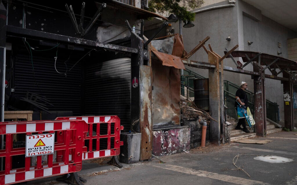 A man walks past a damaged shop, from previous shelling attacks from Lebanon, in Kiryat Shmona, September 17, 2024. (AP/Leo Correa)