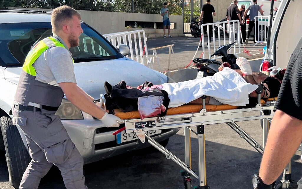 A Civil Defense first-responder carries a wounded man whose handheld pager exploded, at al-Zahraa hospital in Beirut, Lebanon, September 17, 2024. (AP/Hussein Malla)