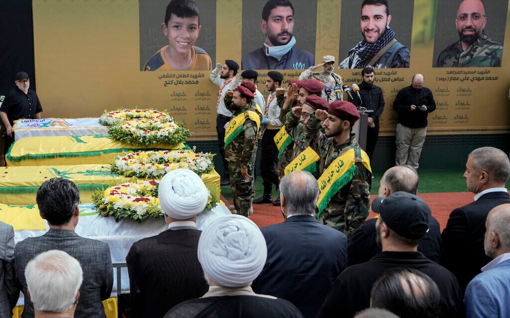 Members of the Hezbollah terror group salute during the funeral procession of four of their comrades who were killed the day before, when their handheld pagers exploded, in a southern suburb of Beirut, Lebanon, on September 18, 2024. (AP Photo/ Bilal Hussein)