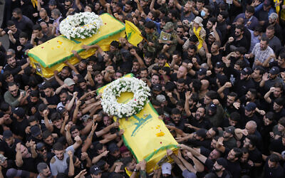 Hezbollah members carry the coffins of two of their comrades who were killed on Wednesday when a handheld device exploded, during a funeral procession in the southern suburbs of Beirut, Thursday, Sept. 19, 2024. Israel has been blamed for the attacks. (AP Photo/Hussein Malla)