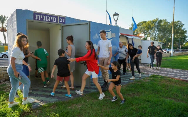 Illustrative: Israelis run to take cover as a siren sounds a warning of incoming rockets fired from Lebanon, in Nahariya, northern Israel, Sept. 19, 2024. (AP Photo/Baz Ratner)
