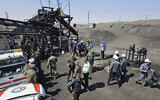 In this photo released by Iranian Red Crescent Society, rescue personnel, police officers and some other people gather around the site of a coal mine where methane leak sparked an explosion on Saturday, in Tabas, some 335 miles (540 kilometers) southeast of the capital Tehran, Iran, Sept. 22, 2024. (Iranian Red Crescent Society, via AP)