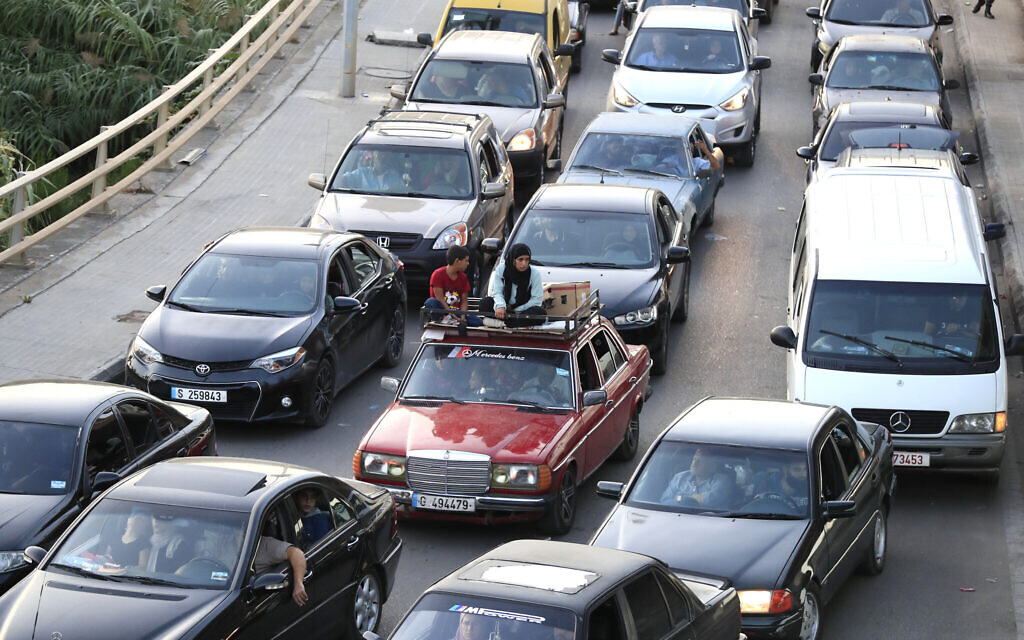 Lebanese citizens fleeing southern villages amid Israeli airstrikes against Hezbollah sit in their cars on a highway that links to Beirut, in the southern port city of Sidon, Lebanon, Sept. 24, 2024. (AP Photo/Mohammed Zaatari)