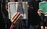 A demonstrator holds up a copy of the Quran, Islam's holy book, during a protest of the burning of a Quran in Sweden, in front of the Swedish Embassy in Tehran, Iran, June 30, 2023. (Vahid Salemi/AP)