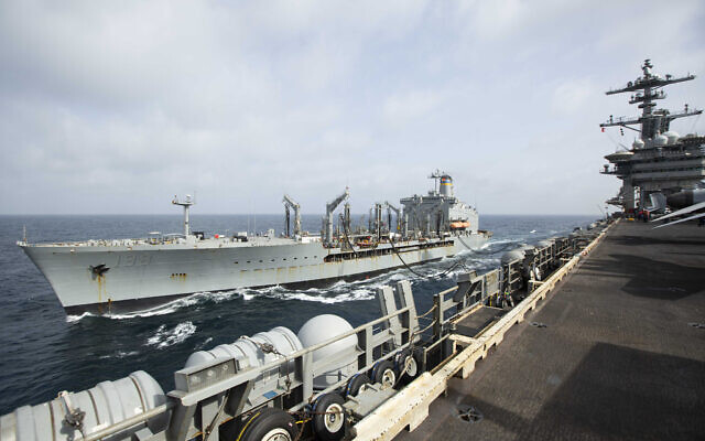 This handout photo from the US Navy shows the Henry J. Kaiser-class fleet replenishment oiler USNS Big Horn sailing alongside the aircraft carrier USS Abraham Lincoln on Sept. 11, 2024, at an undisclosed location at sea in the Middle East. The Big Horn sustained damage in an incident which is under investigation, officials said Tuesday, Sept. 24, 2024. (US Navy via AP)