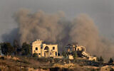 Smoke rises behind a destroyed house following an Israeli airstrike on Hezbollah targets in Khiam village, as seen from Marjayoun town, south Lebanon, Tuesday, Sept. 24, 2024. (AP Photo/Hussein Malla)