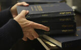 Craig Berko, director of membership at Temple Beth Sholom, prepares to hand out prayer books during a Shabbat service, September 27, 2024, in Miami Beach, Florida. (AP/Wilfredo Lee)