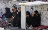 Families sit on the ground in Martyrs' square after fleeing the Israeli airstrikes in Beirut's southern suburbs, Saturday, Sept. 28, 2024. (AP Photo/Bilal Hussein)