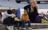 Families fleeing Israeli airstrikes react to the news of the death of Hezbollah leader Hassan Nasrallah in Beirut, Saturday, Sept. 28, 2024. (AP/Bilal Hussein)