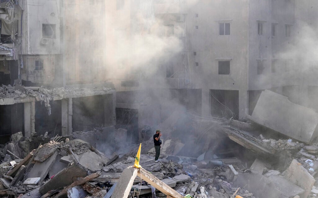 A man stands on the rubble of buildings near the site of the assassination of Hezbollah terror group leader Hassan Nasrallah in Beirut's southern suburbs, September 29, 2024. (AP Photo/Hassan Ammar)