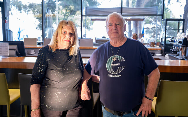 Shlomi evacuees Ella and Avraham Moreno stand in the lobby of their Haifa hotel, September 2024. (Charlotte Lawson/ TOI)