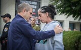 Gal Hirsch, the government's point man on missing and kidnapped citizens, speaks with Einav Zangauker, mother of hostage Matan Zangauker, as he arrives for a meeting with families of Israelis held hostage by Hamas, in Herzliya, December 5, 2023. (Avshalom Sassoni/Flash90)