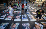 Family members and supporters stand next to pictures of Israelis held hostage in the Gaza Strip, during a protest outside the Prime Minister's official residence in Jerusalem, August 30, 2024. (Yonatan Sindel/Flash90 )