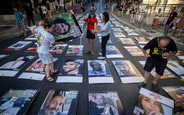 Family members and supporters stand next to pictures of Israelis held hostage in the Gaza Strip, during a protest outside the Prime Minister's official residence in Jerusalem, August 30, 2024. (Yonatan Sindel/Flash90 ) Family members and supporters stand next to pictures of Israelis held hostage in the Gaza Strip, during a protest outside the Prime Minister's official residence in Jerusalem, August 30, 2024. (Yonatan Sindel/Flash90 )