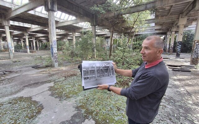 Historian Igor Bartosik at the former Union factory adjacent to Auschwitz, from which female prisoners smuggled revolt supplies to Sonderkommando prisoners living atop Birkenau gas chambers, August 2024 (Matt Lebovic/The Times of Israel)