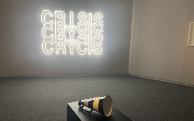 Yael Bartana's 'CRISIS-CRYSIS-CRYCIS,' 2020, Neon, and Guy Zagursky's 'No Lifeguard on Duty (Black Flag),' 2024, Ceramics at the 'I Don't Want to Forget' exhibit at Tel Aviv Museum of Art, opening September 2024 (Jessica Steinberg/Times of Israel)