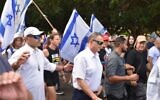 Protesters surround MK Yuli Edelstein as he walks to synagogue in Herzliya the day after three women were arrested for placing hostage flyers in the house of worship, September 14, 2024 (Yair Palti/Pro-Democracy Protest groups)