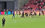 Screenshot of Hapoel Beersheba fans and Bnei Sakhnin fans fighting on the soccer pitch after the latter team's fans turned their backs during the national anthem, Turner Stadium, Beersheba, September 1, 2024. (X;used in accordance with Clause 27a of the Copyright Law)