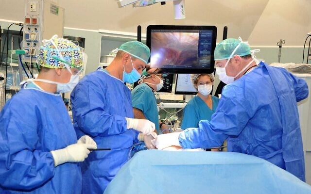Dr. Eli Kakiashvili, right, during an operation using a robot to completely remove a patient's pancreas, in the summer of 2024. (Roni Albert)