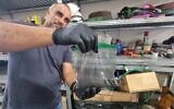 Tomer Aharon, chief operating officer of Batte-Re, with the black powder that is created at the end of the lithium battery recycling process (Aviv Lavie)