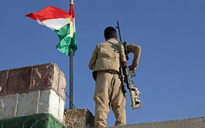 A Kurdish peshmerga fighter affiliated with the Iranian Kurdistan Democratic Party (KDP-Iran) stands guard on a building following an Iranian cross-border attack in the town of Koye (Koysinjaq), 100Km east of Arbil, the capital of the autonomous Kurdish region of northern Iraq on October 1, 2022. (Safin Hamid/AFP)