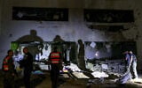 Members of Israel's Home Front Command and police forces inspect a crater left by an exploded projectile at a heavily damaged school building on October 1, 2024, after Iran launched a barrage of missiles at Israel (Menahem KAHANA / AFP)